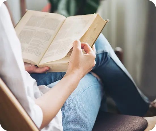 Woman taking a quiet moment for herself with a book, symbolising stress relief and wellbeing