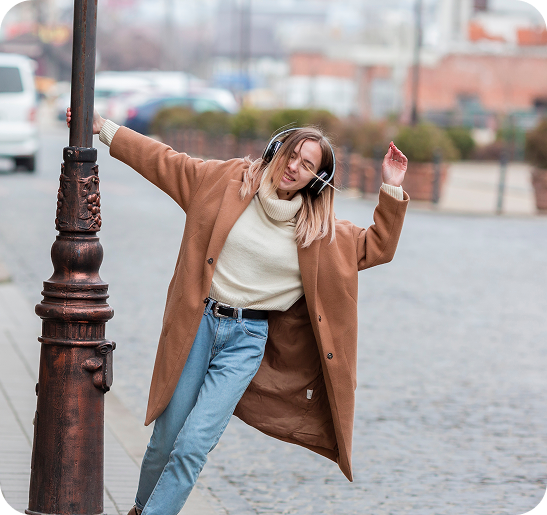 Woman enjoying music and dancing outdoors, expressing joy, freedom, and a positive lifestyle